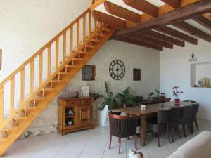ein Wohnzimmer mit einem Tisch und einer Treppe in der Unterkunft Le Temps d'une Pause in Cessieu