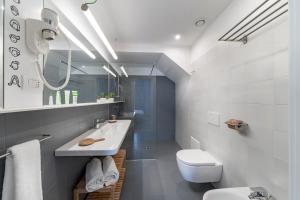 a white bathroom with a sink and a toilet at Hotel Piazza Bellini & Apartments in Naples