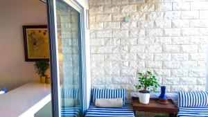 un patio con 2 sillas de rayas azules y blancas y una pared de ladrillo en Porto Terrace, en Espinho