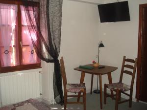 une chambre avec une table, des chaises et une fenêtre dans l'établissement Auberge Aux Portes de Conques, à Saint-Cyprien-sur-Dourdou