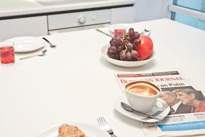 a table topped with a plate of food and a cup of coffee at Platinum Towers Country 2 Country in Warsaw