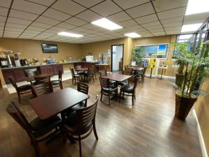 a restaurant with tables and chairs and a bar at Days Inn by Wyndham Owensboro in Owensboro