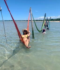 een vrouw in bikini zittend op een boot in het water bij Casa com piscina em c vermelha in Porto Seguro