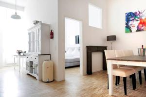 eine Küche und ein Esszimmer mit einem Tisch und einem Kühlschrank in der Unterkunft SC 6 Cozy Family & Business Flair welcomes you - Rockchair Apartments in Berlin