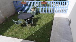einen Tisch und Stühle in einem Garten mit einem Zaun in der Unterkunft studio 2 personnes entre campagne et plages in Questembert