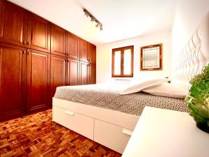 a bedroom with a large bed and wooden cabinets at Appartamento Alice in Bardolino