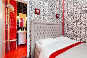 een slaapkamer met een bed en een rode en zwarte muur bij Cozy studio for couple near Polytechnic University in Lviv