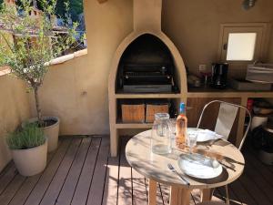 a patio with a table and a pizza oven at La Maison de Moustiers in Moustiers-Sainte-Marie