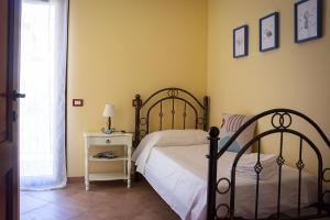 - une chambre avec un lit et une table avec une lampe dans l'établissement Maya Holiday Home, à Villasimius