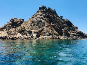 an island in the ocean with blue sky and water at Bike&Boat Argentario Hotel in Porto Santo Stefano