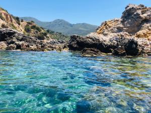 a body of water next to some rocks at Bike&Boat Argentario Hotel in Porto Santo Stefano