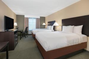 Days Inn & Suites by Wyndham Florence/Jackson Area tesisinde bir odada yatak veya yataklar