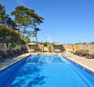 a swimming pool with blue water in a yard at Haven Hall Hotel in Shanklin