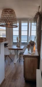 a dining room with a table and a view of the ocean at Opaline Baie de somme in Ault