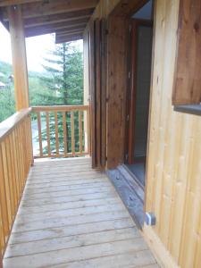 a wooden porch of a cabin with a window at Charmant T2 en DUPLEX ARAVET113 in La Salle-les-Alpes
