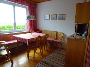 ein Esszimmer mit Tisch und Stühlen und einem Fernseher in der Unterkunft Bungalow Raschun Grabelsdorf Etruskerweg 12 / 9122 St. Kanzian in Grabelsdorf