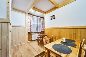 a dining room with a wooden table and chairs at Noclegi u Hanki in Bukowina Tatrzańska