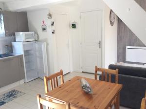 ein Wohnzimmer mit einem Holztisch und einer Küche in der Unterkunft GITE CHEZ XAVIER 2Mn DU CIRCUIT in Magny-Cours