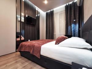 een slaapkamer met een groot bed en een televisie bij Marcel Apartments in Belgrado