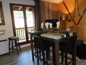 a kitchen with a table with chairs and a balcony at Charmant T2 en DUPLEX ARAVET113 in La Salle-les-Alpes