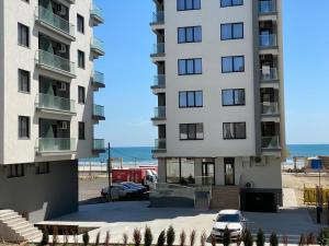 a large white building next to a beach at Apartament Ella D25 Mackerel in Mamaia Sat/Năvodari