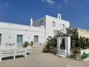 a white building with potted plants in front of it at Masseria Fulcignano in Galatone