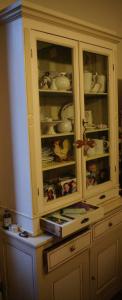 une armoire blanche avec de la vaisselle dans l'établissement B&B Canto Alla Porta Vecchia, à Pistoia