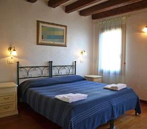 a bedroom with a blue bed with two towels on it at Oceano Mare B&B in Venice