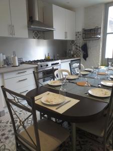 una cucina con tavolo, piatti e bicchieri di Auberge des chemins a Moissac