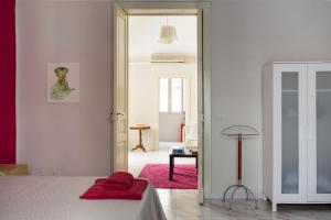 una camera bianca con un letto e un tappeto rosa di The Good Place a Catania