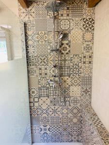 y baño con ducha y pared de azulejos. en Le gîte du bois Greffier en Flêtre