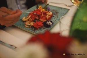 een persoon die een bord eten op een tafel bij Gelso Bianco Country Resort in Savignano sul Panaro