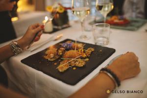 una persona sentada en una mesa con un plato de comida en Gelso Bianco Country Resort, en Savignano sul Panaro