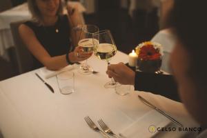 un gruppo di persone seduti a un tavolo con bicchieri da vino di Gelso Bianco Country Resort a Savignano sul Panaro