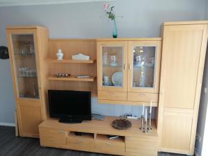 a wooden entertainment center with a television in it at Feriendomizil Familie Finke in Weener +14 photos