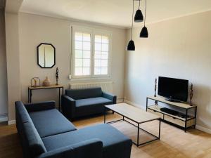 a living room with a couch and a tv at Harmonie Tergnier in Tergnier