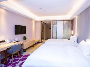 Cette chambre comprend un grand lit et un bureau. dans l'établissement Lavande Hotel Nanchang West Railway Station Guobo Subway Station, à Nanchang