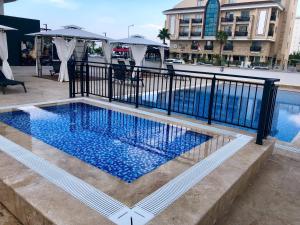 a swimming pool with a black fence next to a building at ONLY ONE Suites & Residences in Antalya