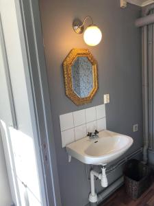 uma casa de banho com um lavatório e um espelho na parede em Hunnebostrands vandrarhem Gammelgården em Hunnebostrand