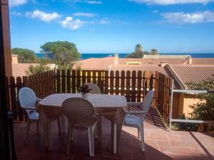 Una mesa y sillas en un patio con vista al mar. en VistaMare, en Villaputzu