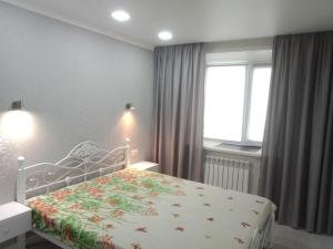 a bedroom with a bed and a window at 2х комнатная квартира на Назарбаева 44 in Pavlodar