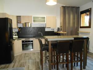 a kitchen with a table and some chairs in it at Charmant T2 en DUPLEX ARAVET113 in La Salle Les Alpes