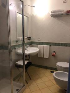 a bathroom with a sink and a toilet and a mirror at Amalfitano Apartments in Amalfi