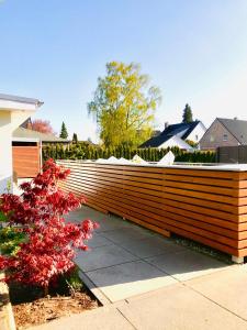 a wooden fence in front of a house at Wunderschöne Wohlfühloase im Grünen mit Innenstadtnähe in Ellerbek