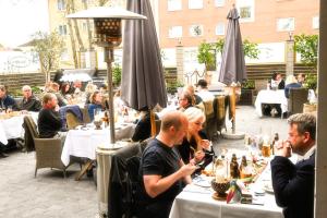 a group of people sitting at tables in a restaurant at Palace Hotell in Hultsfred