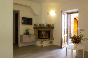 a living room with a fireplace and a table at La casa di Elvira in San Gusmè