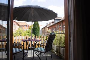 einen Tisch und zwei Stühle mit Sonnenschirm auf dem Balkon in der Unterkunft Stadtflucht Lüneburg: Ferienwohnungen Innenstadt in Lüneburg