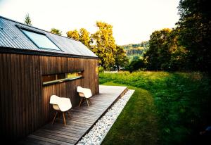 twee stoelen op een houten terras naast een gebouw bij refugium am see in Seeboden