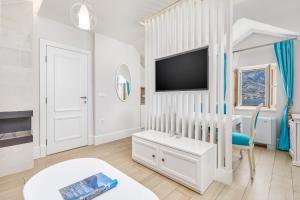 Hotel Libertas في كوتور: غرفة معيشة بيضاء مع تلفزيون وأريكة
