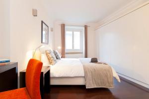 een witte slaapkamer met een bed en een raam bij Baxia-Chiado Apartment with Incredible view in Lissabon